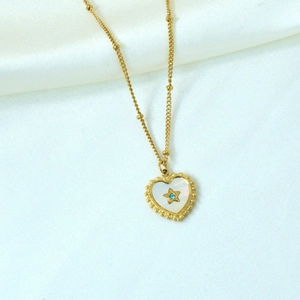 Detail of 14K gold heart pendant with white shell inlay and blue star gem on bead chain