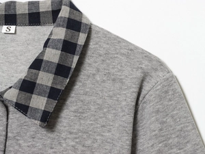 Detail of color-block polo collar and knitted texture on grey short sleeve top