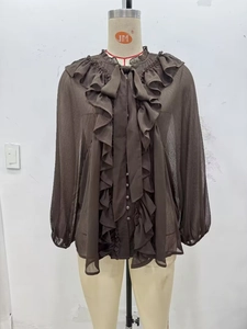 Detail of dark brown chiffon blouse featuring tiered ruffles and bow tie neckline