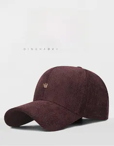 Close-up of herringbone pattern baseball cap in dark purple with gold crown emblem