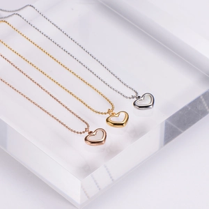 Élégant collier pendentif cœur en nacre dorée, argentée et rosée sur une chaîne à billes