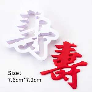Detail showing white plastic mold for Chinese character Shou and red embossed dough sample