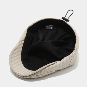 Detail of British style checkered hat showing breathable black lining and adjustable cord