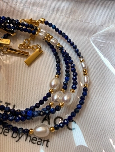 Détail macro de perles d'eau douce et perles de lapis-lazuli avec chaîne d'extension dorée