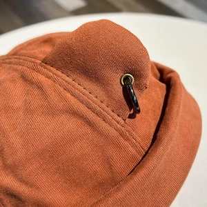 Close-up of caramel knit beanie featuring cat ear detail and black metal rings