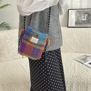Détail du petit sac à bandoulière en peluche avec motif à carreaux et bandoulière