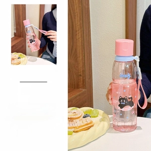 Detailed view of pink cartoon cat plastic water bottle with handle strap and matte lid