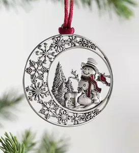 Detailed view of a metal Christmas tree ornament with snowman, reindeer and red ribbon
