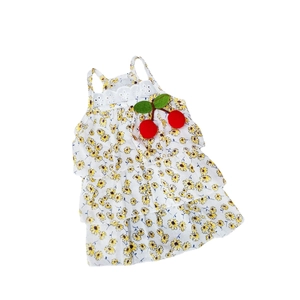 Detail of floral pet dress with yellow daisies and red cherry ornaments on white mesh