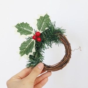 Détail d'une couronne de bougie de Noël avec baies rouges et feuilles givrées sur rotin