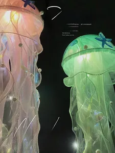 Detail view of pink and green LED jellyfish lamps with gauze tentacles and seashell decor