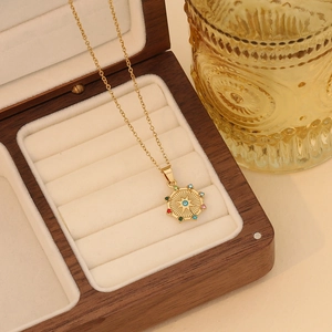 Detailed shot of starburst eye pendant with colored gemstones on a gold necklace