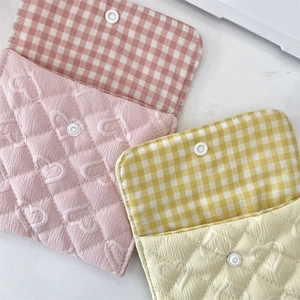 Detail of pink and yellow quilted heart pouches with classic plaid lining and snap closure