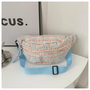 Detail of orange checkered woven belt bag with adjustable light blue strap and knot zip pull