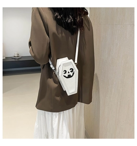 Detailed view of coffin-shaped crossbody bag with ghost print and white PU leather strap