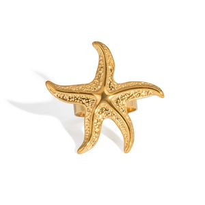 Détail macro d'une bague étoile de mer dorée avec surface métallique texturée de style marin