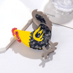Detailed view of the rooster shaped acetate hair claw clip with colorful bird design