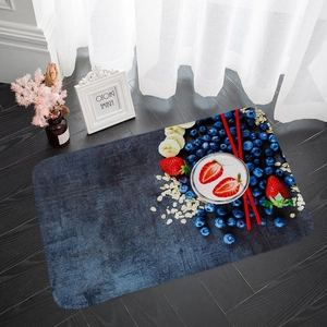 Detailed top view of absorbent flannel mat with vibrant fruit print on dark wooden floor