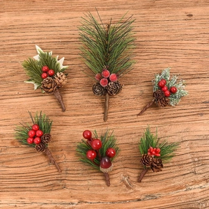 Detail of Christmas picks with red berries pine needles and cones on dark wood background