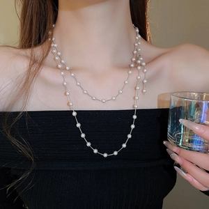 Collier double couche en perles synthétiques porté par un mannequin élégant