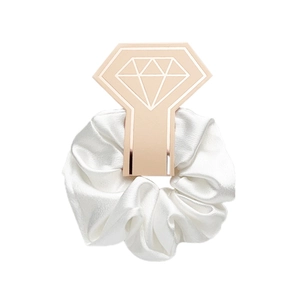 Close-up of white satin scrunchie with elegant rose gold diamond-ring shaped card