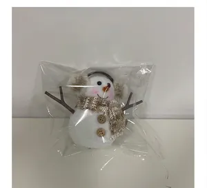 Detailed view of glowing Christmas snowman ornament in its transparent protective packaging