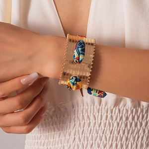 Detail of gold wide cuff bracelet with ethnic print fabric inlay and beaded edges