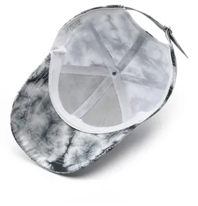 Detailed interior view of a gray tie-dye baseball cap showing the care label