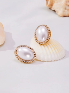 Macro detail of French vintage oval pearl earrings with sparkling crystal accents
