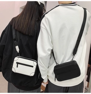 Detail showing two fashion mini box crossbody bags in black and white with wide straps