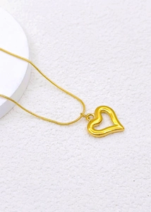 Detailed view of a gold-plated hollow heart pendant on a delicate snake bone chain