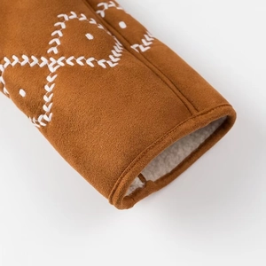 Detail view of brown suede sleeve featuring white lamb wool lining and cross embroidery