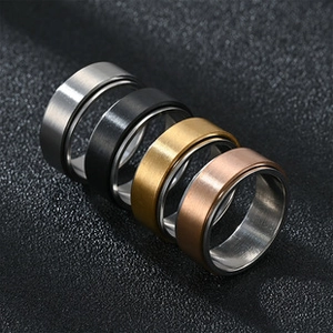 Detail of four brushed titanium steel spinner rings in silver, black, gold and rose gold