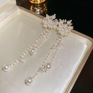 Detail of elegant pearl tassel earrings with glass beads in a luxury jewelry box