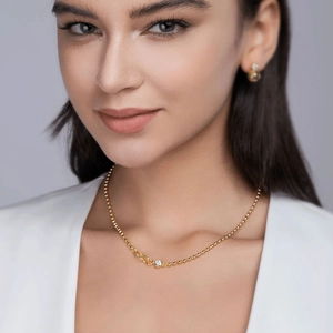 Elegant model wearing a gold beaded 925 silver necklace with a moissanite pendant and studs