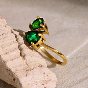 Close-up of golden stainless steel ring with two green pear-shaped zircon stones