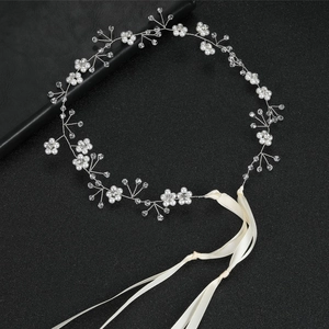Detailed bridal hair vine with faux pearls and crystals on silver wire over dark background