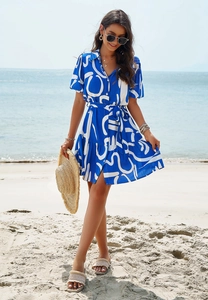 Detail of blue and white geometric print short sleeve shirt dress with waist tie on beach