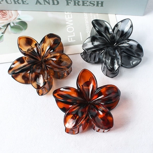 Three elegant matte flower hair claws in amber, tortoiseshell, and translucent grey