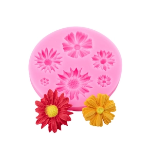 Pink silicone flower mold for cake decorating with red and yellow fondant samples