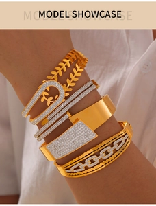 Détail de bracelets dorés superposés avec motif épi et cristaux sur mannequin