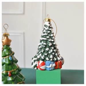 Detail of Christmas tree ornament with 3D snow and gift box accents on a festive hanging hook