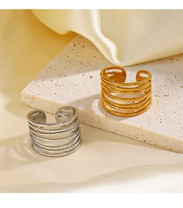 Detailed view of layered gold and silver stainless steel rings on a marble surface