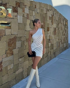 Détail de la robe tricotée blanche à une épaule avec découpe latérale et texture rayée
