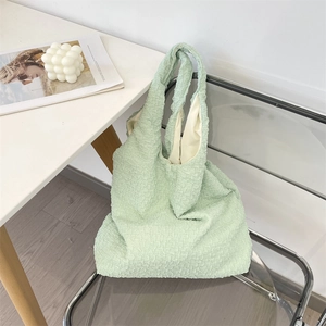 Detail of mint green tote bag featuring unique bubble pleated texture and sturdy strap