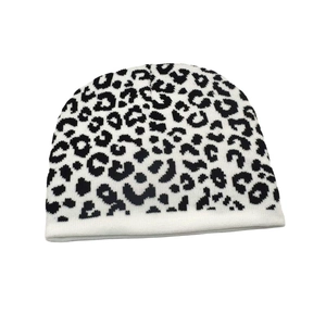 Close-up of the dense knit texture and black leopard print on this beige winter beanie