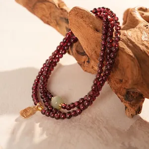 Three-layer pomegranate garnet beaded bracelet with green jade and gold Fu charm pendant