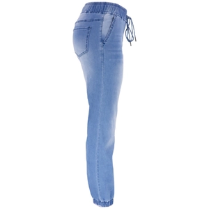 Détail du jogging en jean bleu montrant la taille élastique avec cordon et les chevilles