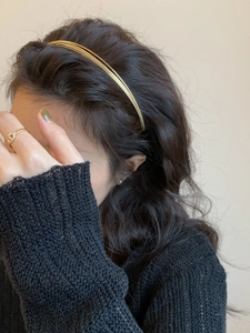 Detailansicht eines mehrlagigen goldenen Metall-Haarreifs mit minimalistischem Design am Modell
