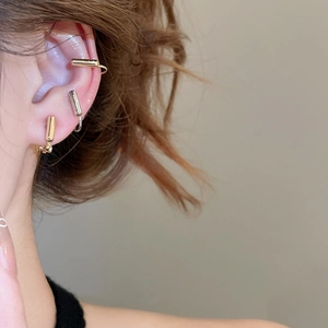 Close-up of minimalist gold and silver geometric ear bone clips on a model's ear